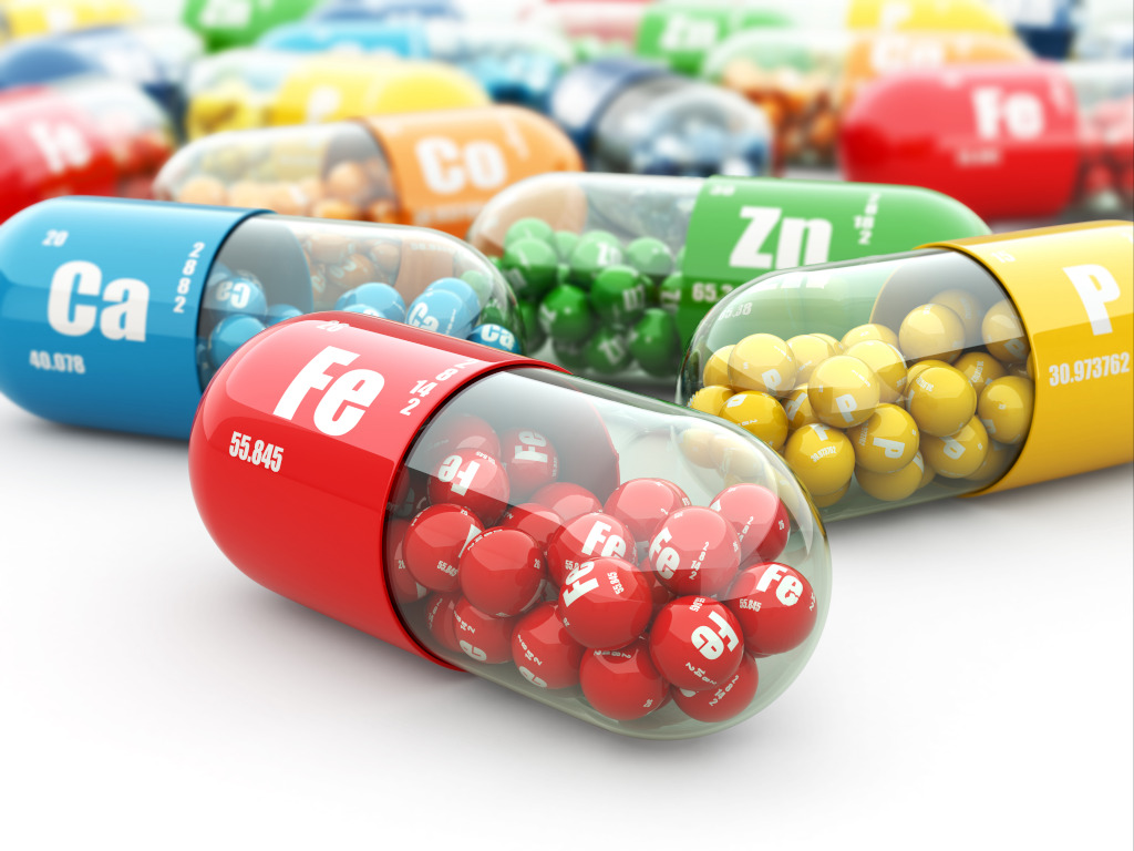 Very colorful photo with several capsules. This is not a real image, but one created by
computation, where each capsule has several spheres inside, demonstrating that each
capsule is full of many things.
The capsules on that white table are, in the center a red one with the initials “FE” for
Iron; on the left side, a blue one with the initials “Ca” for Calcium; On the right, a yellow
one with the initial’s “P” for Phosphorus. Behind the yellow one with “Zn” for Zinc and
further back one with the initials “Co” for Cobalt. It is possible to see more than 10
colored capsules behind these, but without being able to identify all of them.