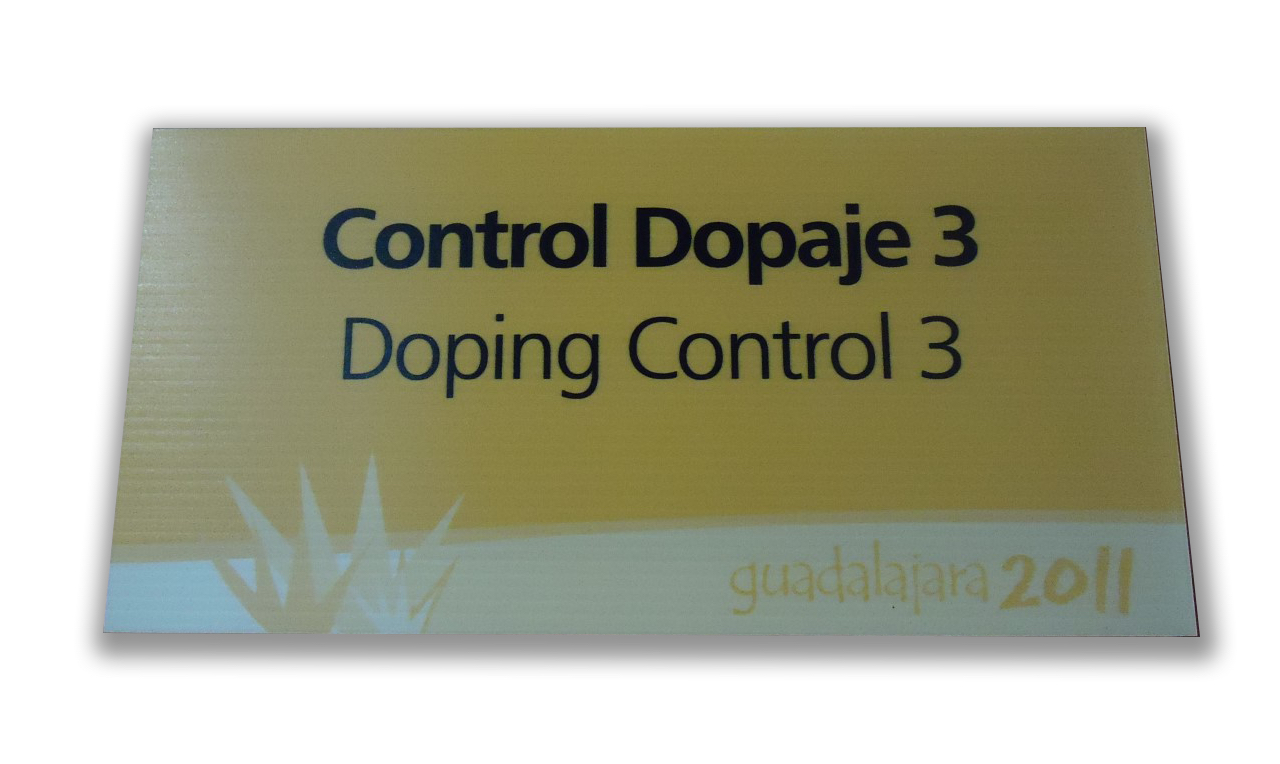 Photo of a yellow and white signpost.
On this plate it is possible to read “Control Dopaje 3” below “Doping Cotrol 3” and in
the footer of the plate “Guadalajara 2011” and the logo of the event.